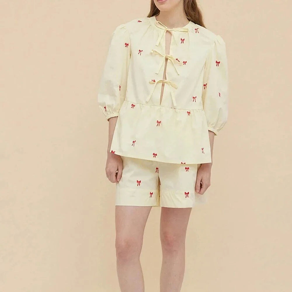 A stylish bow-embroidered shorts set featuring a delicate hollow-out short sleeve top and comfortable, stretchy fabric for effortless summer style.