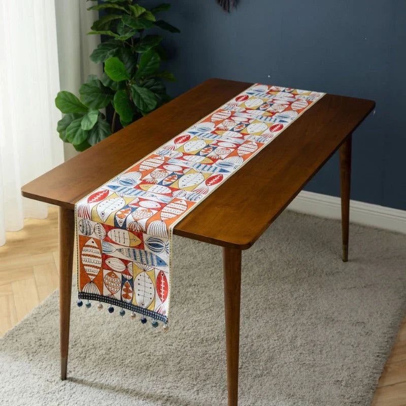 Festive jacquard table runner with vibrant fish design, available in multiple sizes to fit various dining tables