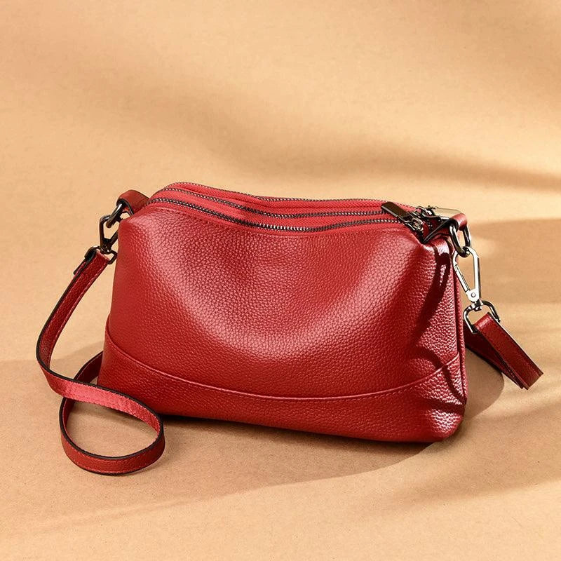 Cowhide shoulder bag in various colors, featuring a sleek and modern design with multiple internal pockets for organization.