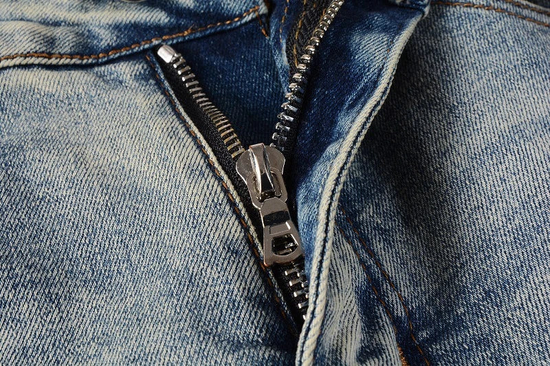 American High Street fashionable men's ripped black and white patch jeans in a light blue denim color