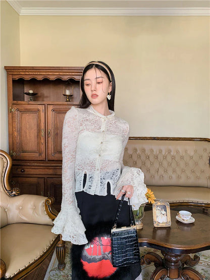 Elegant lace patchwork blouse with ruffled long sleeves and a button-down front in a classic off-white and black color palette.