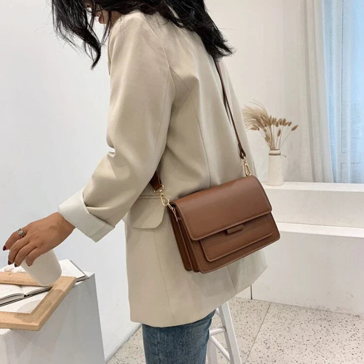 Stylish black crossbody shoulder bag with adjustable strap and multiple interior compartments for modern women