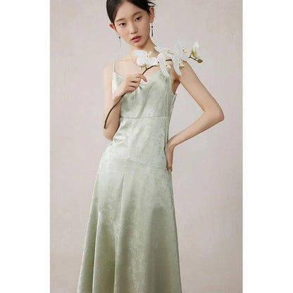 Elegant mint green midi dress with spaghetti straps, featuring a slim fit and intricate embroidery details