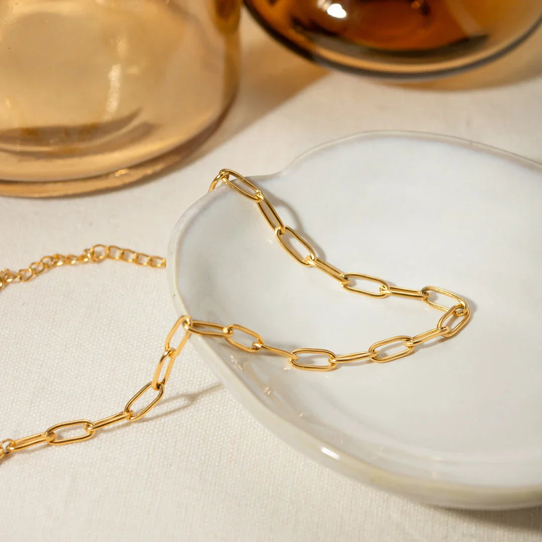 A close-up view of a 18K gold-plated stainless steel paper clip chain anklet, showcasing its elegant and minimalist design.