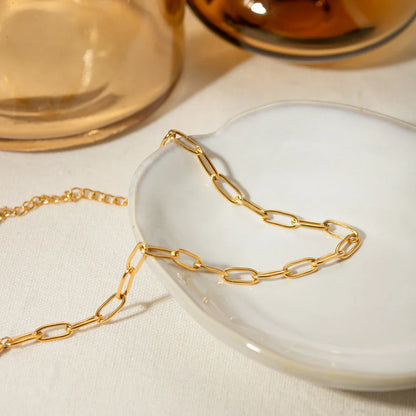 A close-up view of a 18K gold-plated stainless steel paper clip chain anklet, showcasing its elegant and minimalist design.