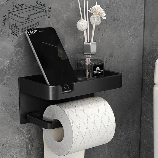 Black and gold aluminum bathroom paper holder with a convenient phone shelf, a stylish and functional accessory for modern bathrooms.