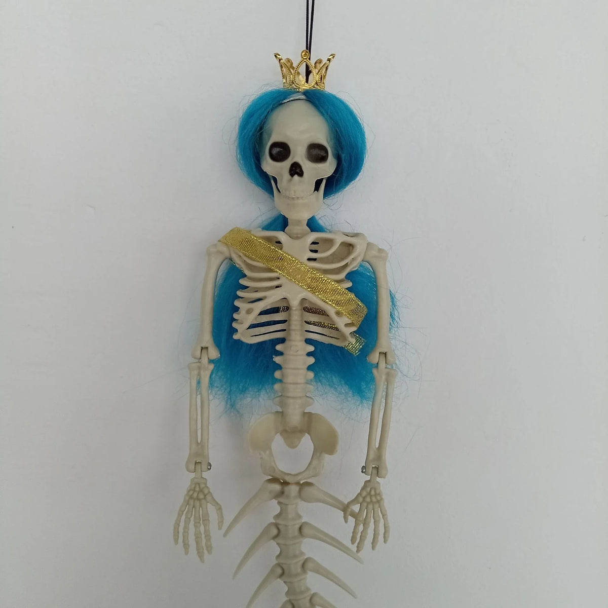 Mermaid bone pendant in various colors, including brown, dark purple, burgundy, and lake blue, hanging outdoors for Halloween decoration