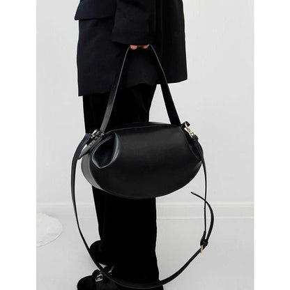 Circular vegan leather handbag in a tan color, with a sturdy build and thoughtful interior design for versatile use.