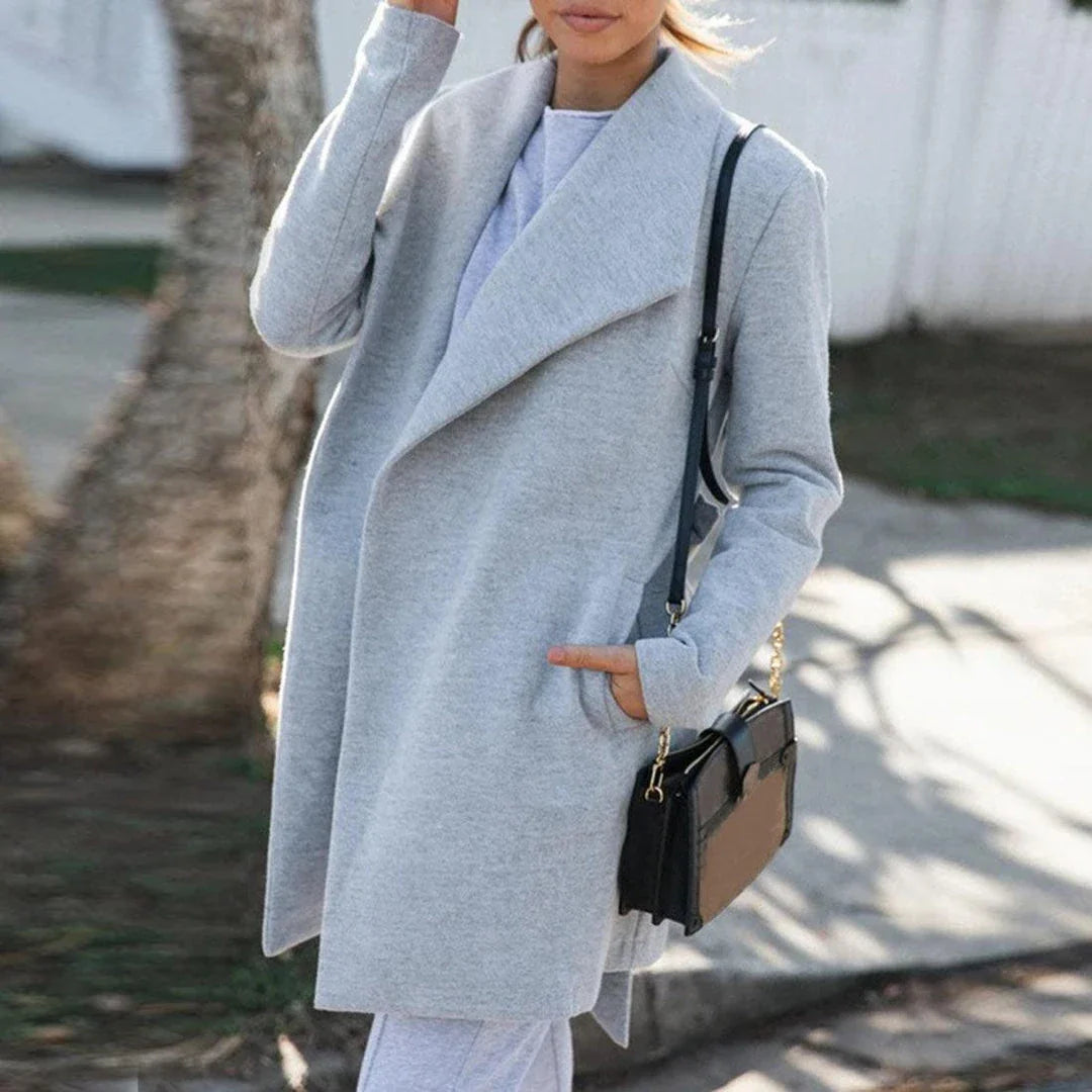 A versatile polyester trench coat in grey, featuring a classic silhouette and convenient design for easy layering over any outfit.