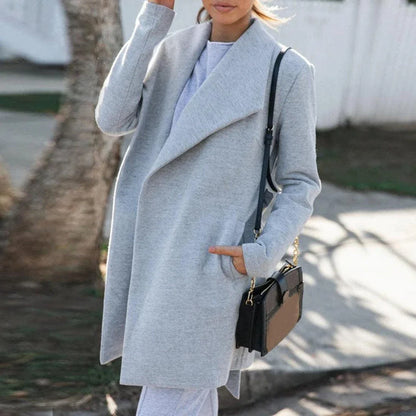 A versatile polyester trench coat in grey, featuring a classic silhouette and convenient design for easy layering over any outfit.