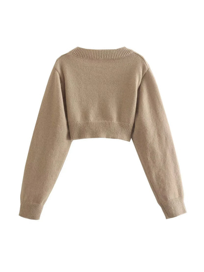 A cozy, knitted pullover sweater with a timeless round neck design, available in a versatile camel color.