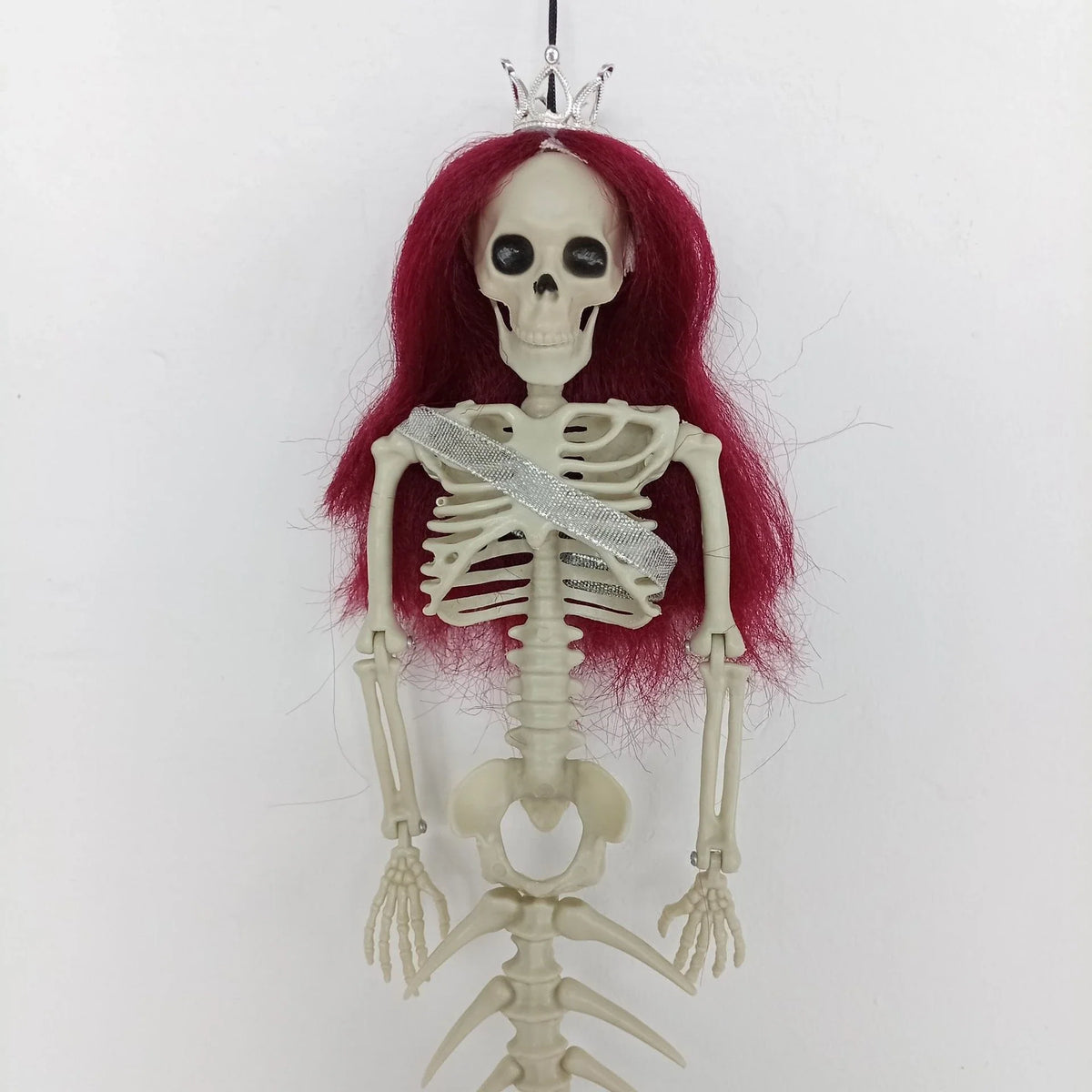 Mermaid bone pendant in various colors, including brown, dark purple, burgundy, and lake blue, hanging outdoors for Halloween decoration