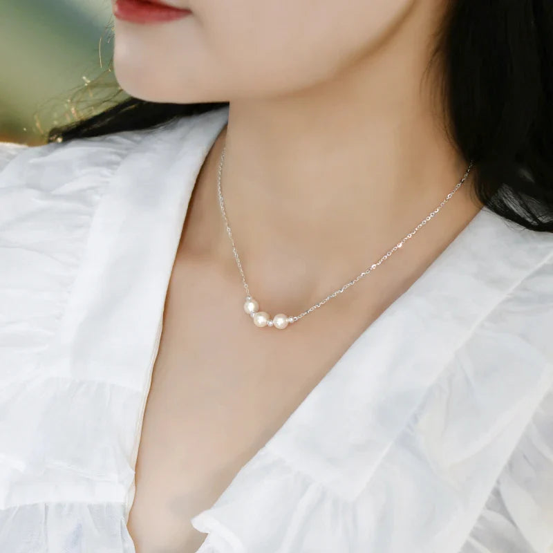 A close-up shot of a natural freshwater pearl necklace with a silver chain in a stylish multi-chain design.