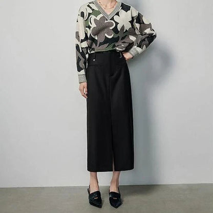 High-waisted slim-fit black midi skirt with metallic decoration, sequin detailing, and split hem