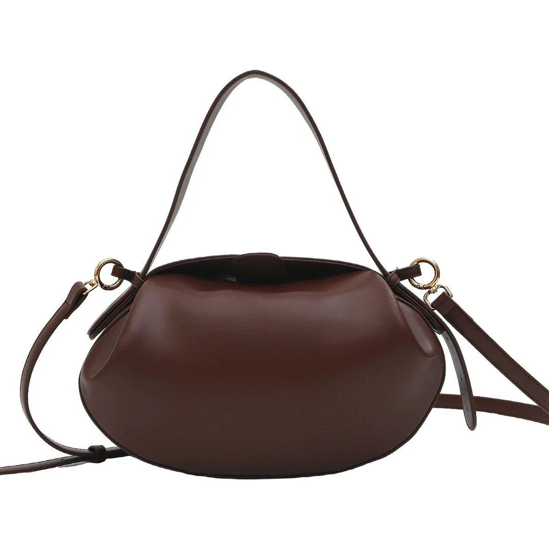 Circular vegan leather handbag in a tan color, with a sturdy build and thoughtful interior design for versatile use.
