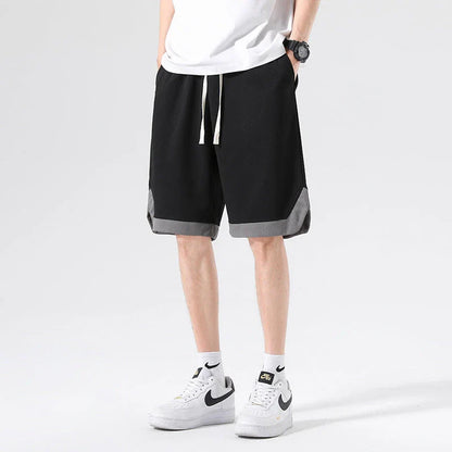 Men's loose and comfortable sports pirate shorts in white, gray, and black colors with elasticized waistband and relaxed fit