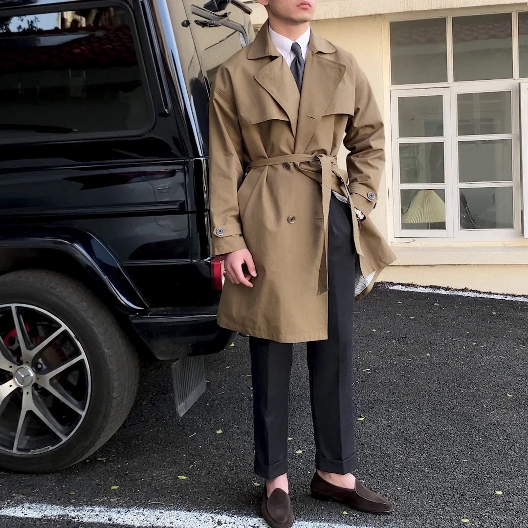 Commuter-friendly mid-length trench coat with double-breasted lapels, made from durable cotton-polyester blend fabric