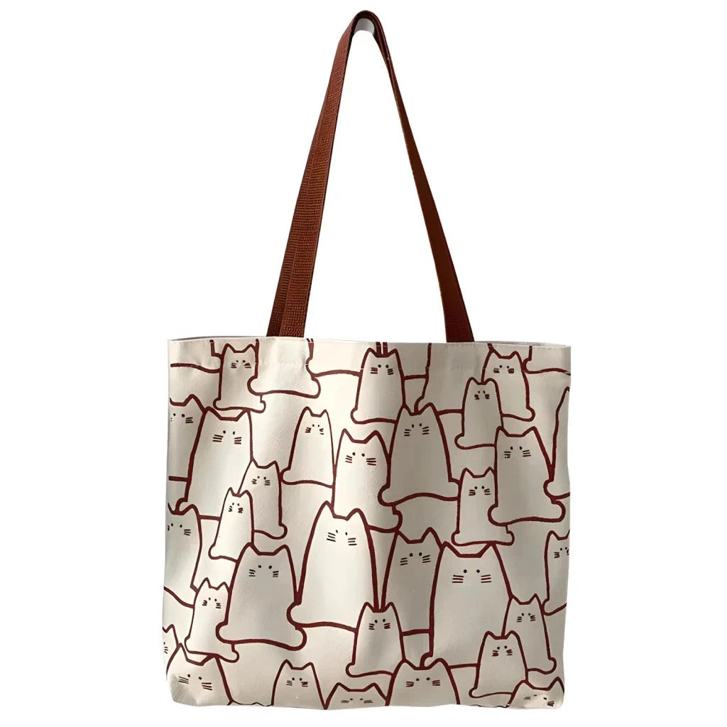 Beige cat-themed canvas handbag with adjustable strap and zipper closure, offering ample storage space for everyday use
