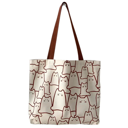 Beige cat-themed canvas handbag with adjustable strap and zipper closure, offering ample storage space for everyday use