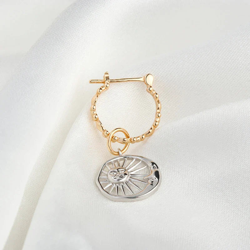 Elegant silver earrings with a geometric sun and moon design, perfect for adding a touch of celestial style to any outfit.