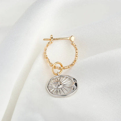 Elegant silver earrings with a geometric sun and moon design, perfect for adding a touch of celestial style to any outfit.