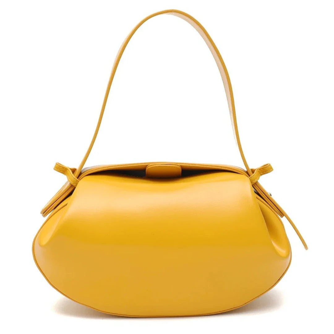 Circular vegan leather handbag in a tan color, with a sturdy build and thoughtful interior design for versatile use.