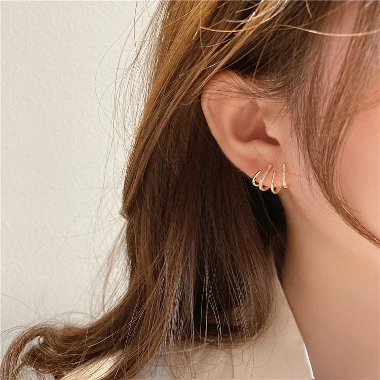 Elegant gold-toned zircon four-claw stud earrings with a classic cuff design, offering a sparkling and sophisticated look.