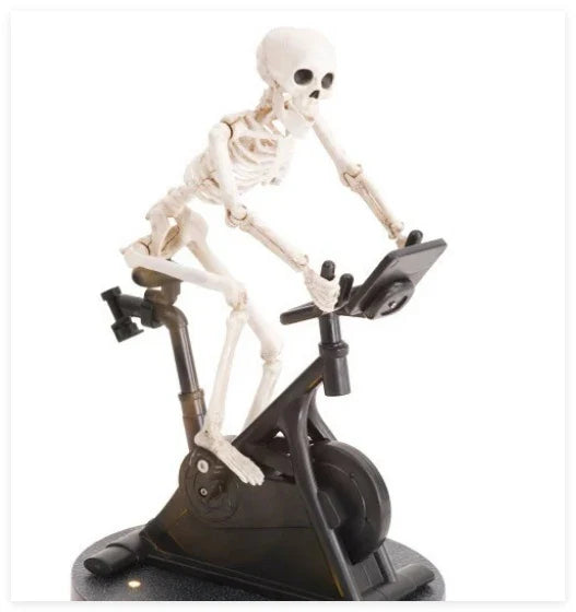 Animated skeleton cycling ornament in white, with the skeleton gracefully pedaling a tiny bicycle