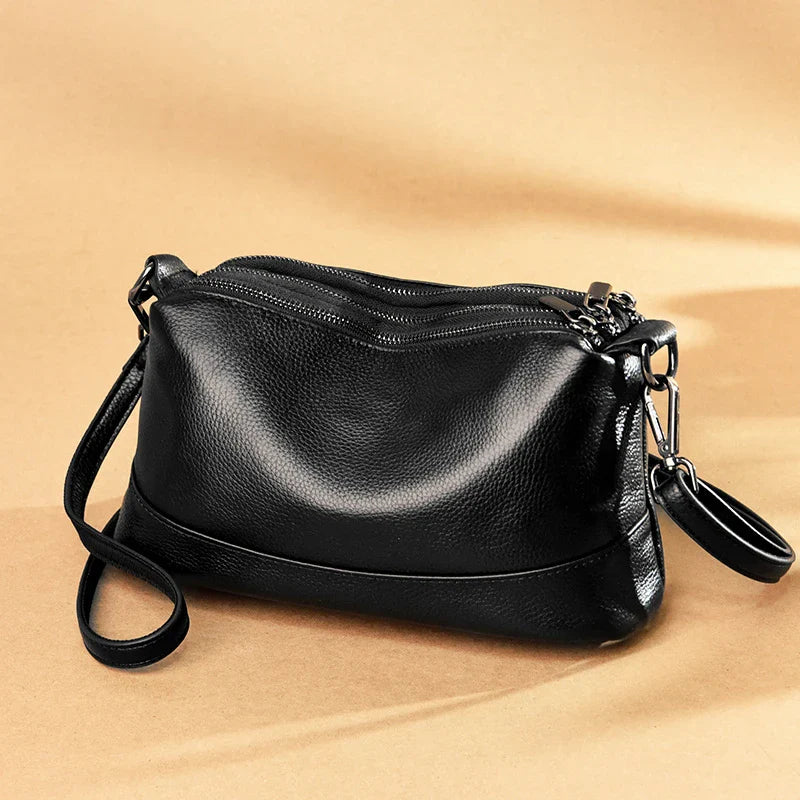 Cowhide shoulder bag in various colors, featuring a sleek and modern design with multiple internal pockets for organization.