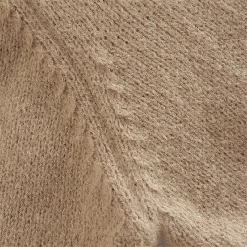 A cozy, knitted pullover sweater with a timeless round neck design, available in a versatile camel color.