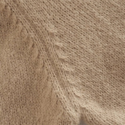 A cozy, knitted pullover sweater with a timeless round neck design, available in a versatile camel color.