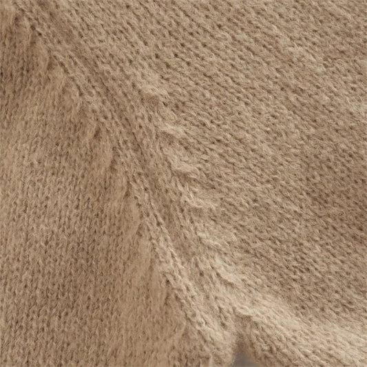 A cozy, knitted pullover sweater with a timeless round neck design, available in a versatile camel color.