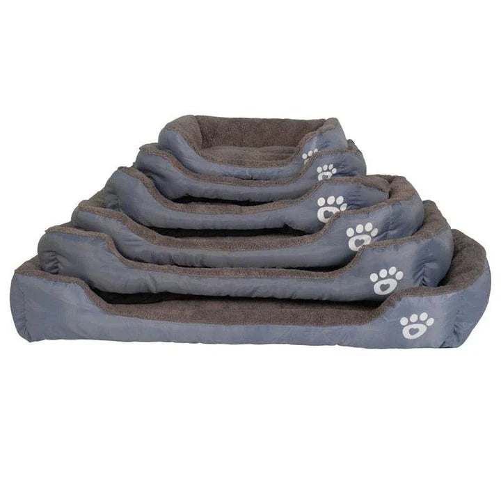 A plush, green pet bed with a paw-print pattern, designed to provide cozy and waterproof comfort for pets.