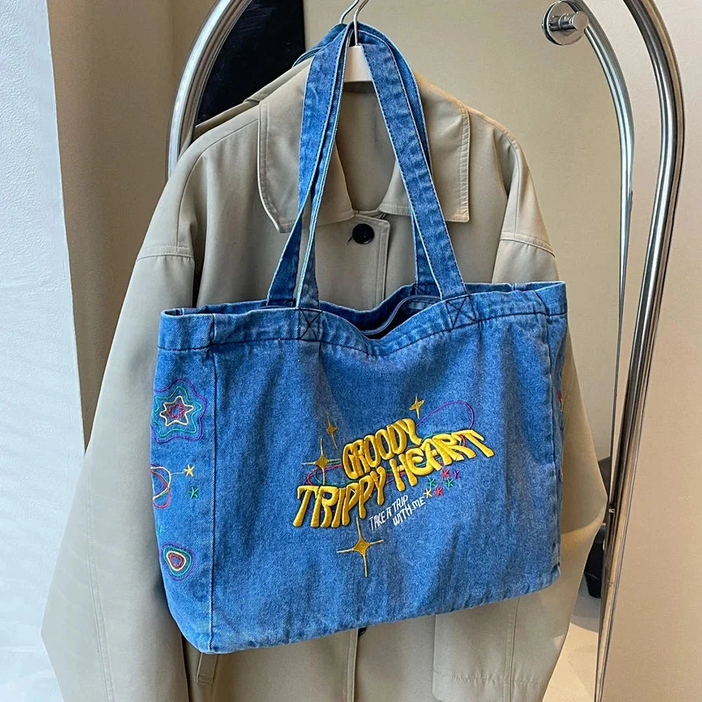 A stylish denim shoulder bag with embroidered details, perfect for everyday use and carrying all your essentials