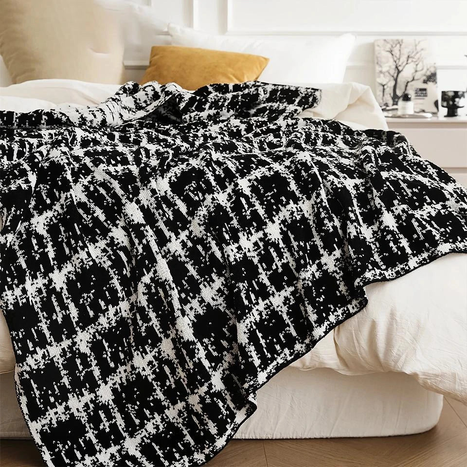 Luxurious white and black plaid wool knit blanket for cozy home, travel, and relaxation