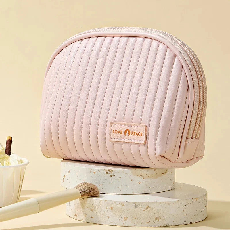 Stylish compact makeup bag made of premium PU leather in light blue color, with a sleek minimalist design for modern women