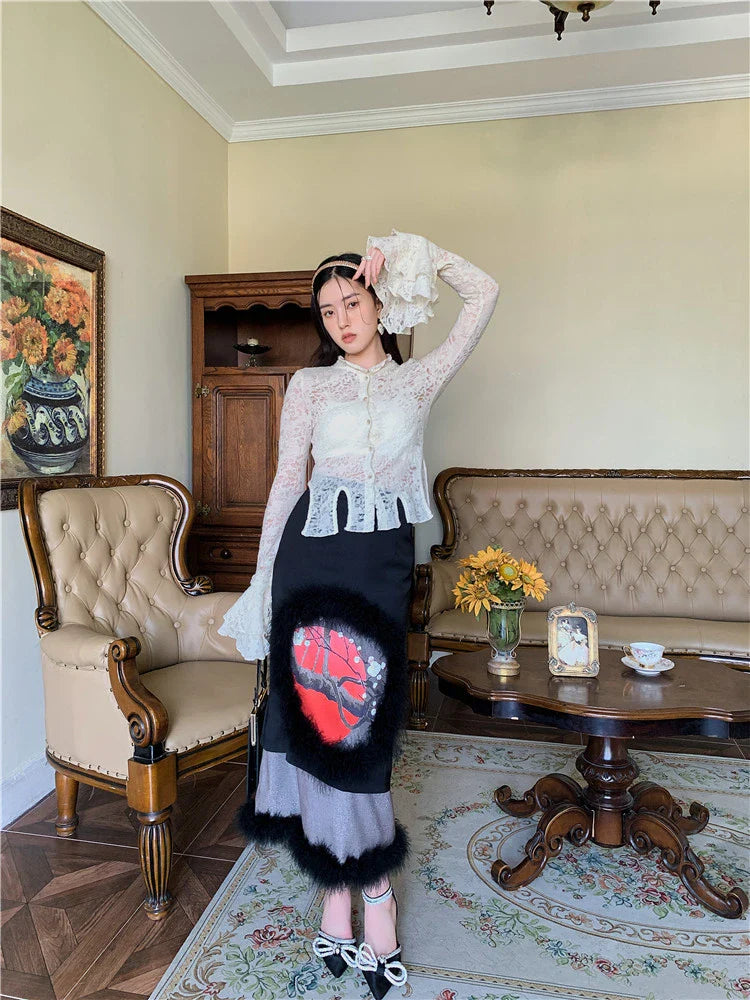 Elegant lace patchwork blouse with ruffled long sleeves and a button-down front in a classic off-white and black color palette.