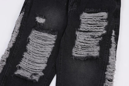 Premium loose fit distressed denim trousers for men and women, featuring a relaxed silhouette, high-quality cotton construction, and trendy distressed details.