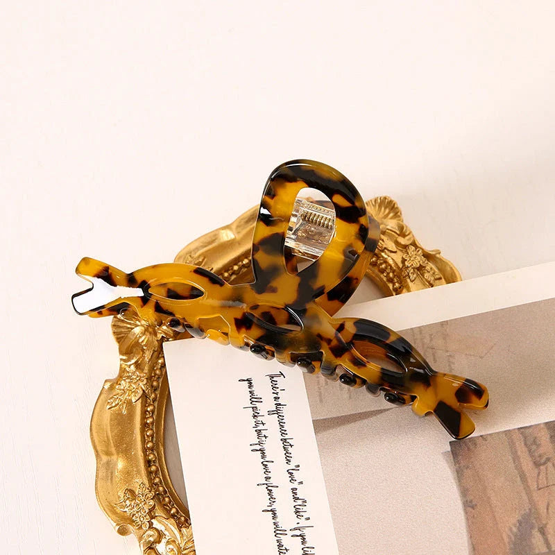 Elegant leopard print large weave hair clip for women and girls, made with durable acrylic and alloy materials for a secure and comfortable hold.