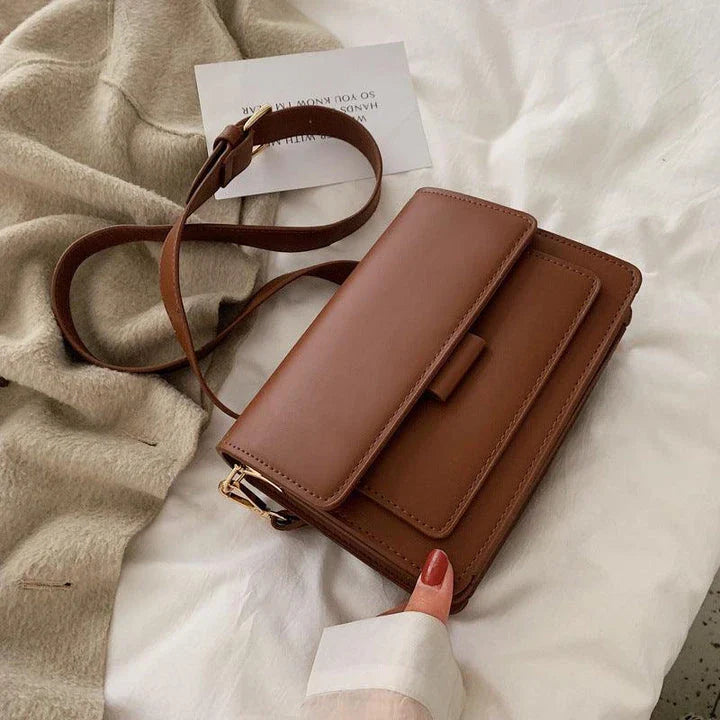 Stylish black crossbody shoulder bag with adjustable strap and multiple interior compartments for modern women
