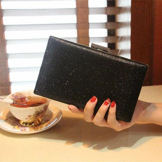 A shiny, metallic dinner clutch bag with a detachable chain strap for versatile carrying options