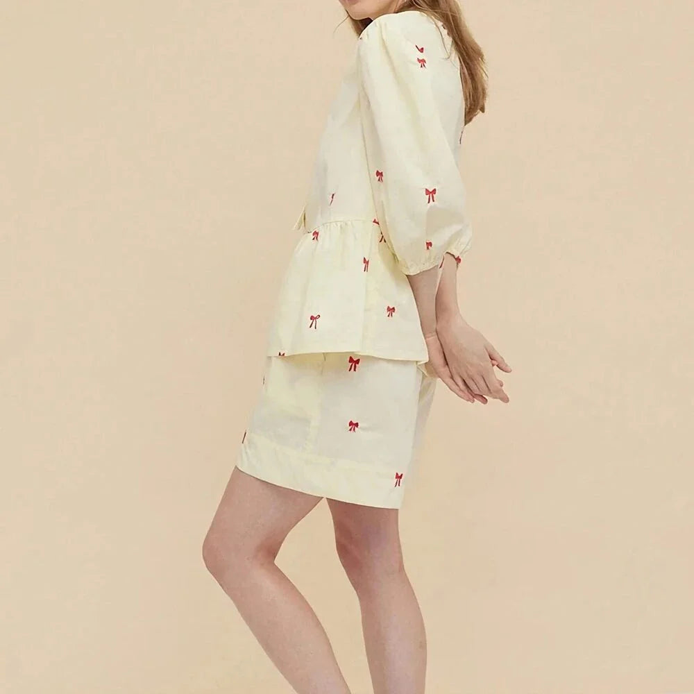 A stylish bow-embroidered shorts set featuring a delicate hollow-out short sleeve top and comfortable, stretchy fabric for effortless summer style.