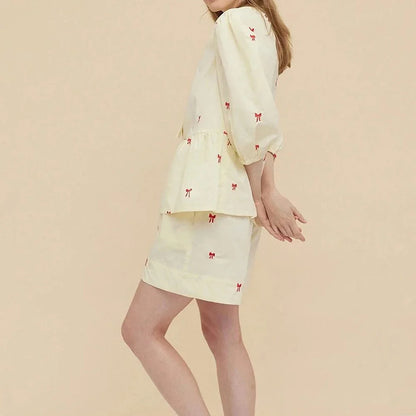 A stylish bow-embroidered shorts set featuring a delicate hollow-out short sleeve top and comfortable, stretchy fabric for effortless summer style.