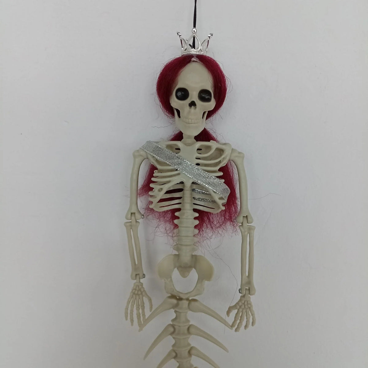 Mermaid bone pendant in various colors, including brown, dark purple, burgundy, and lake blue, hanging outdoors for Halloween decoration