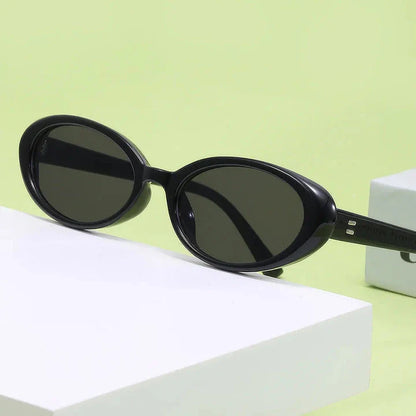 Chic oval sunglasses with white grey acetate frames and polycarbonate lenses, designed for fashionable women to shield their eyes from UV rays in style.