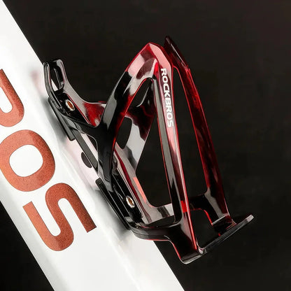 A stylish, lightweight cycling bottle holder with a two-tone design, securely holding a water bottle on a bike.