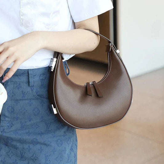 Elegant leather shoulder bag in a half-moon shape, featuring a sleek polyester lining and organized interior pockets for modern women's fashion.