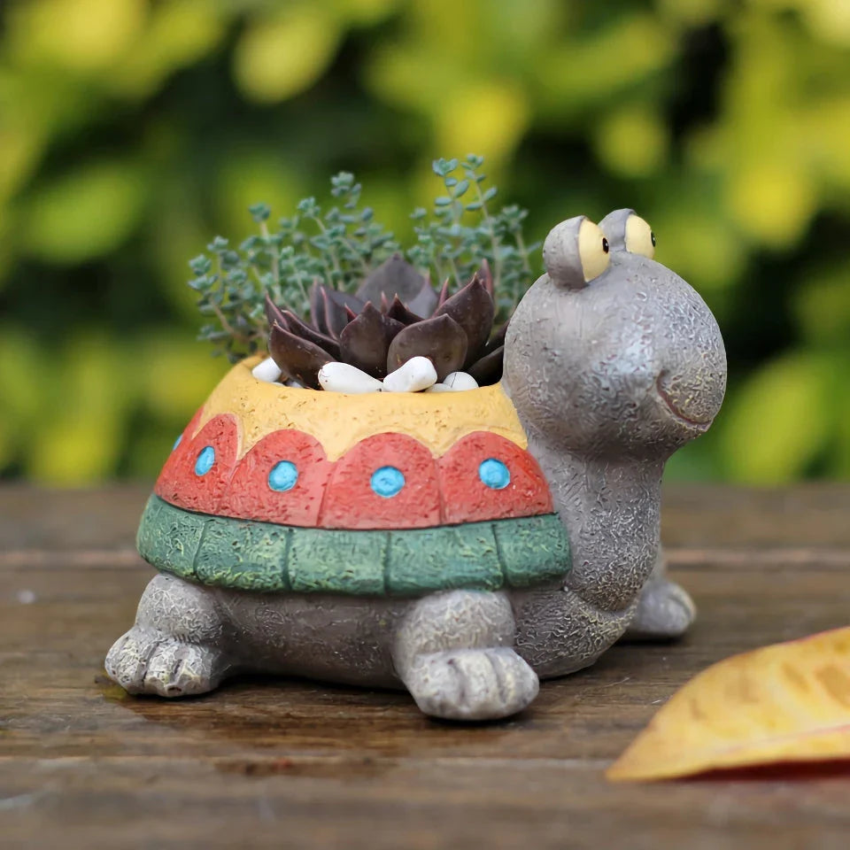 Charming gray cartoon turtle planter holding small potted succulents and cacti