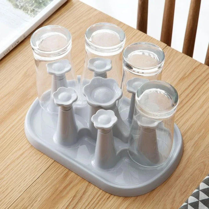 Flower-shaped mug holder rack in white, with 8 slots for organizing and displaying mugs on a kitchen countertop