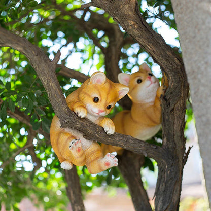 Charming resin cat statue with lifelike details, climbing on a tree branch and adding whimsical flair to any garden or indoor space.